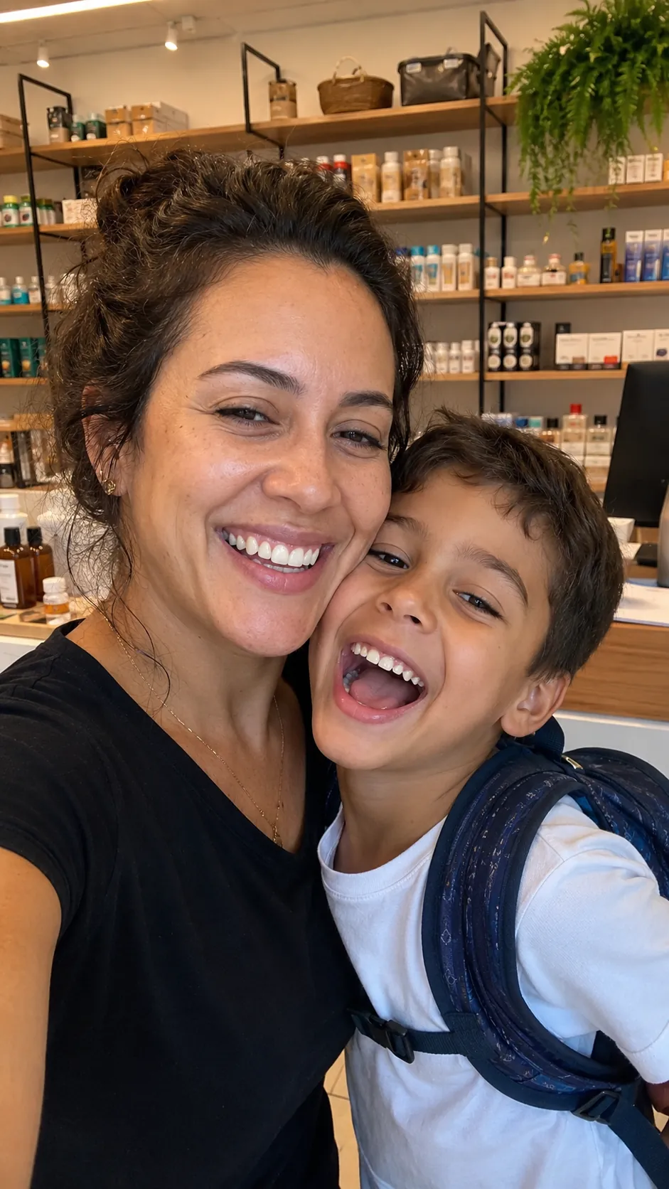 Empreendedora sorrindo com o filho na sua loja
